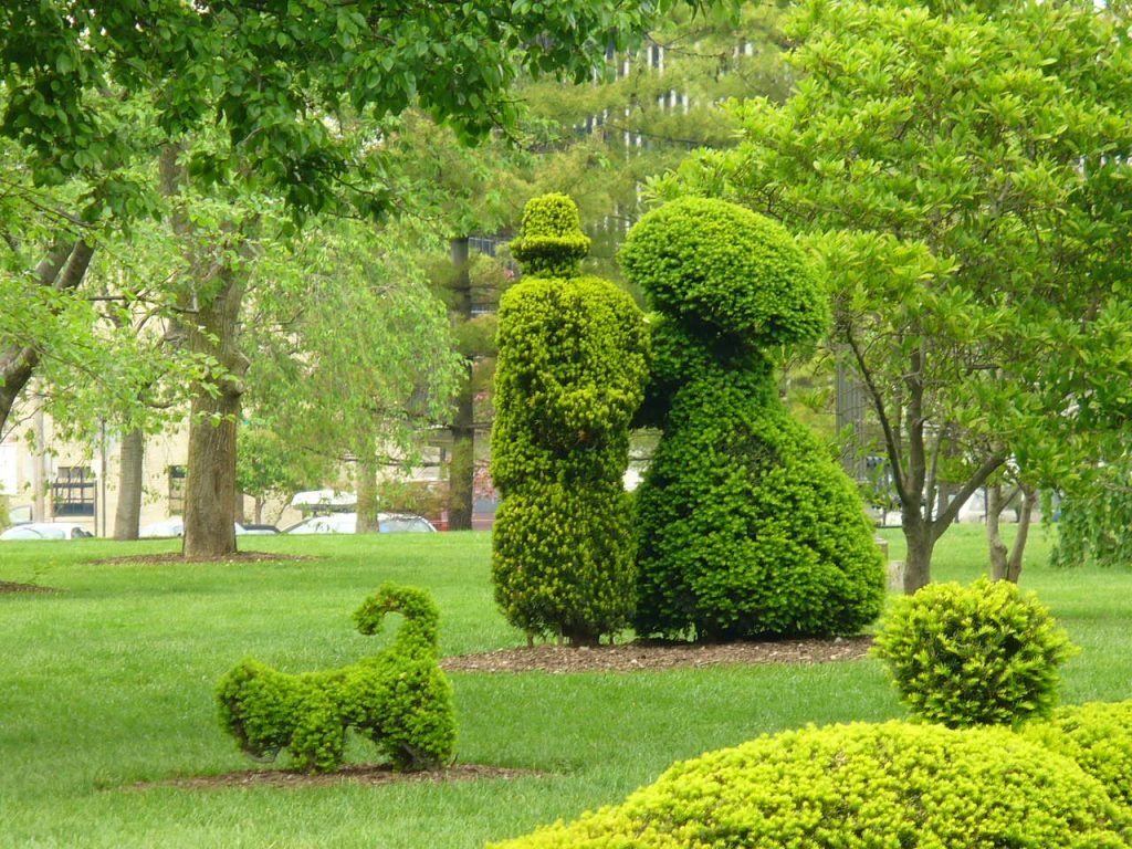 Man, woman, dog topiary image